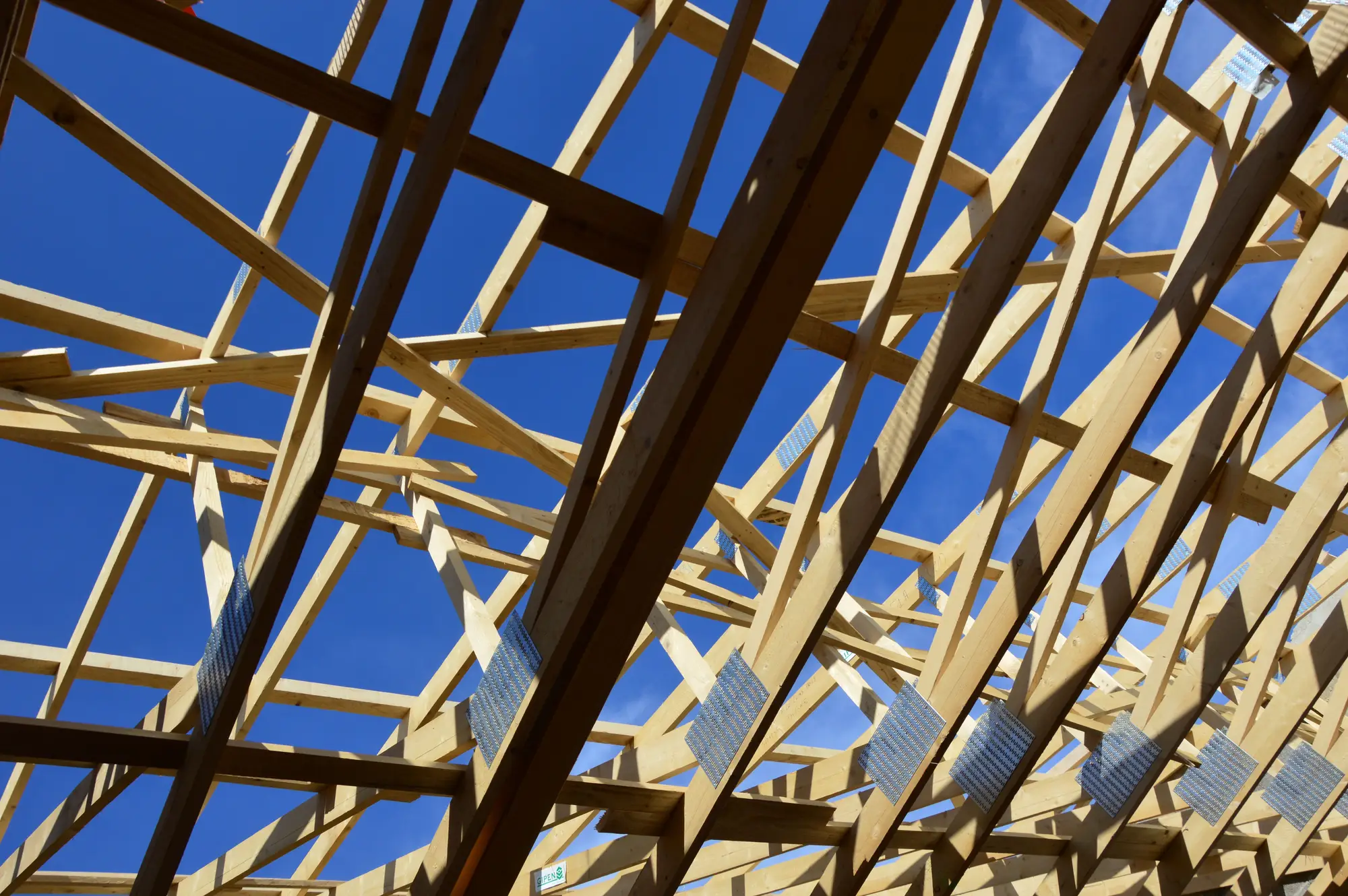 Roof trusses on a house under construction, seen from the deck below